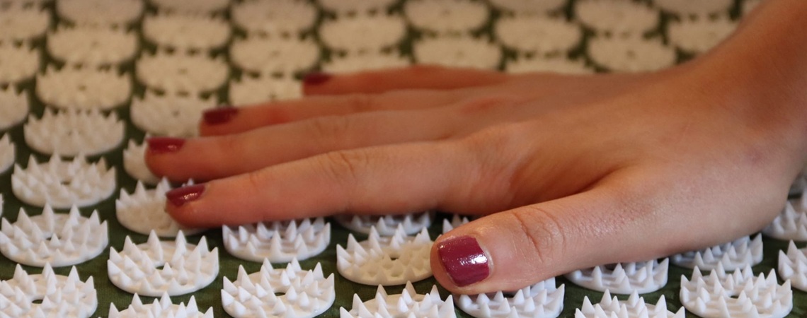 Hand liegt auf einer Akupressurmatte Hand liegt auf einer Akupressurmatte